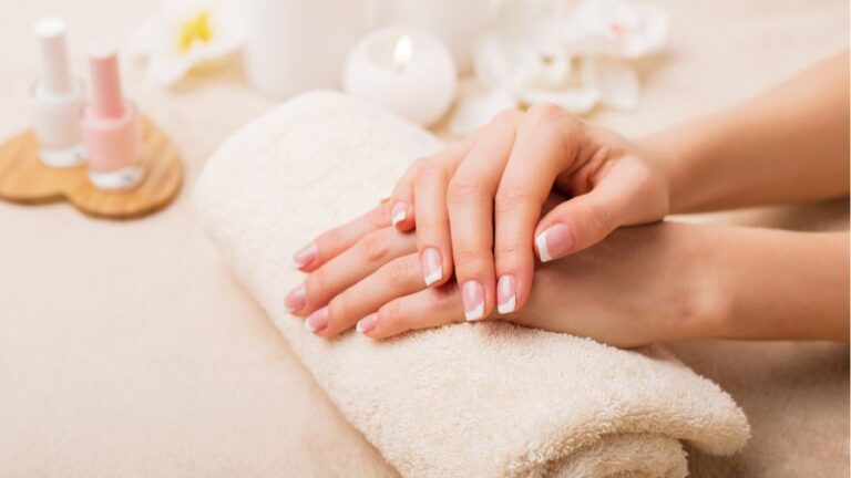 Kobiece ręce z zadbanymi paznokciami na ręczniku